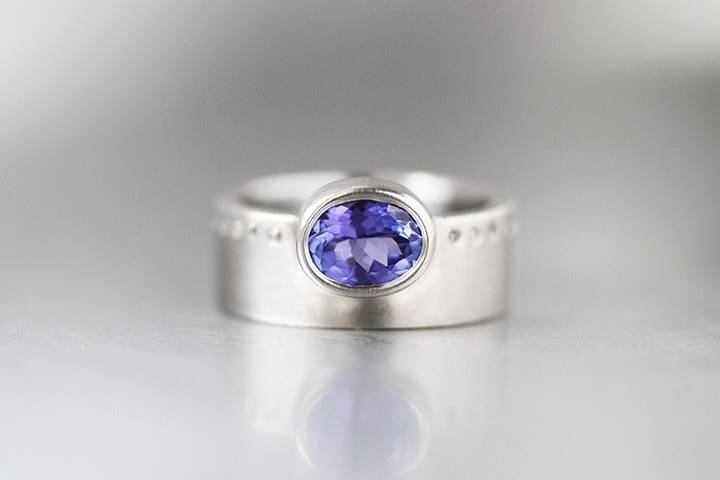 Custom created tanzanite ring in palladium band with top light brown diamonds