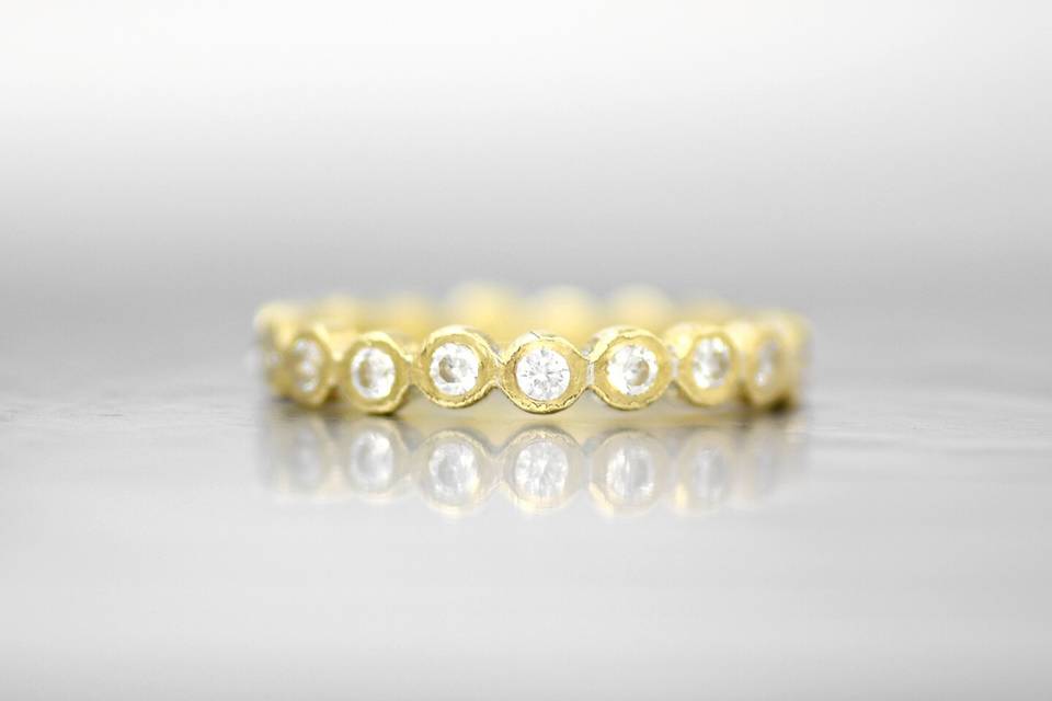ATHENSThis eternity band adds shape and elegance with a soft row of diamond bezels. The signature Wanderlust texture creates a subtle and organic feel that will wear perfectly over time.