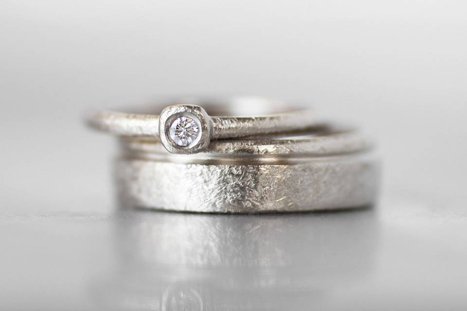 Matching white gold wedding bands with tiny bezel diamond accent