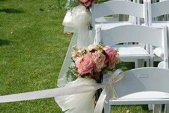 full floral bouquets with ivory organza draping created a fairy tale walkway for this outdoor wedding.