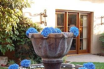 Floating blue hydrangea heads and white rose petals enhanced the fountain featured at the ceremony site.