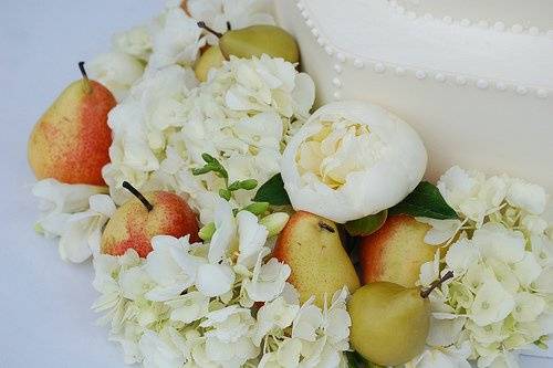 Fresh pears nestled into a bed of hydrangea and peonies at the base of the cake