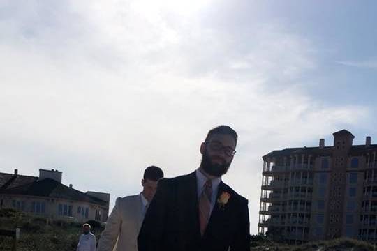 Groom and officiant walking to the venue