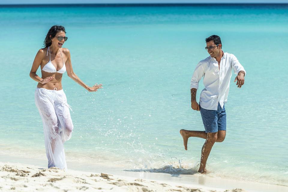 Newlyweds playing on beach