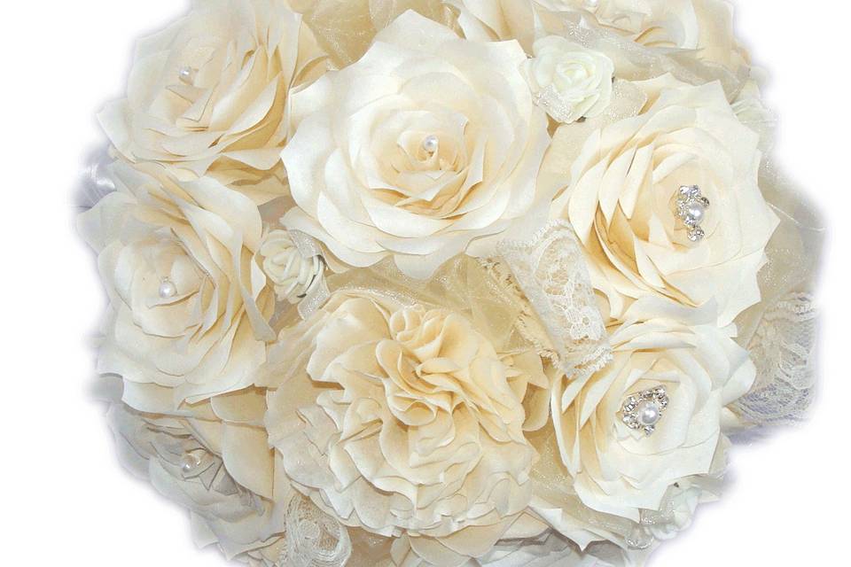 This romantic lace bouquet is made of ivory paper filter Roses and carnations with pearls and rhinestones in the center of the top flowers. In between the flowers there is lace, shimmering tulle and delicate foam flowers for accent. The stems are wrapped in Ivory satin ribbon and delicate lace around the stems with small ivory satin bows at the base of the flowers. Bouquet is shown in a medium and small size. Each flower petal is hand cut, individually painted, hung to dry, assembled and shaped to create the perfect Rose.