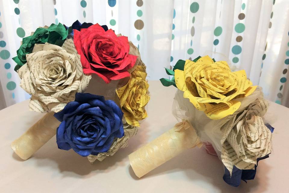 Harry Potter book page bouquets in three different sizes. Bouquet is shown with red, blue, yellow, green and natural colored Roses surrounded by ivory tulle. The handle is wrapped in ivory satin ribbon, lace and bows. Colors can be customized.