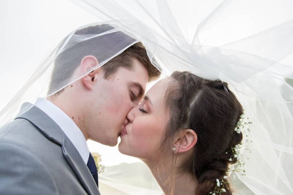 Bride & Groom kissing veil