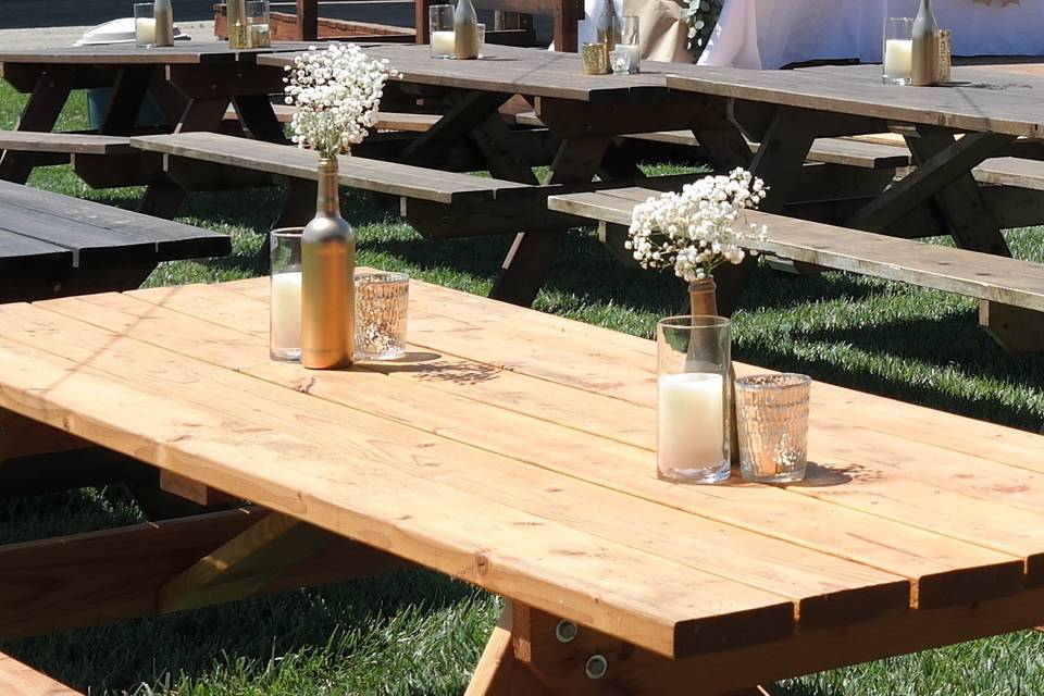 Simple outdoor reception with DIY gold bottles adorned with baby's breath and surrounded by simple mercury glass votives.
Styling: AWE Productions.