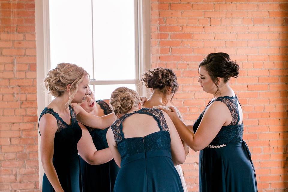 Bridesmaids assisting the bride