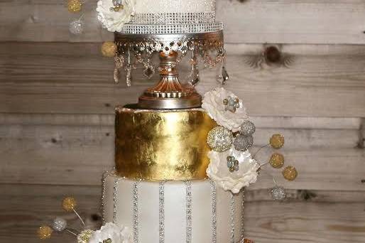 REAL edible gold leaf on second tier.  Underlit cake stand separator adds sparkle & drama.