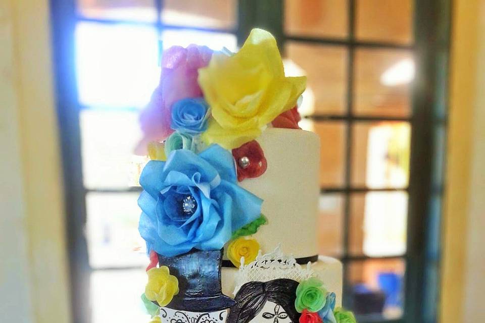 Dia de los Muertos (Day of the Dead) themed wedding cake with sugar skull cut-outs and wafer roses