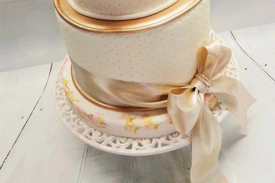 modern romantic fondant cake with delicate wafer flowers, gold accents, hand painted floral pattern, and soft textured icing
