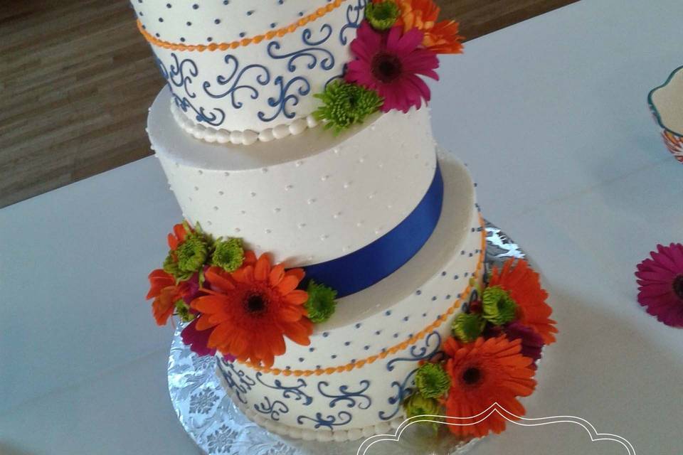 buttercream wedding cake with colorful piping and fresh flowers