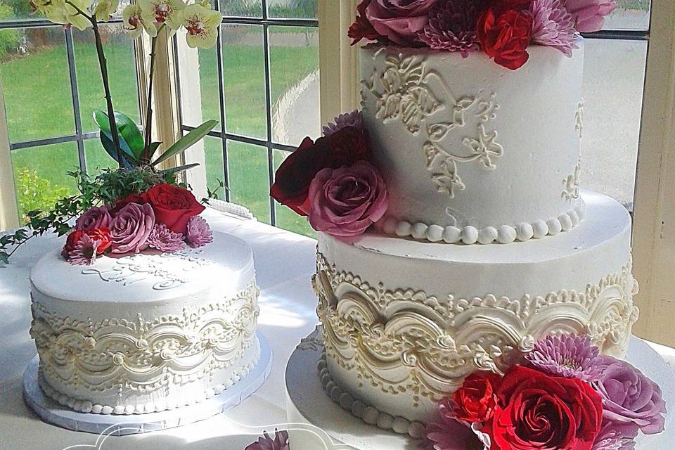 buttercream wedding cake with colorful piping and fresh flowers