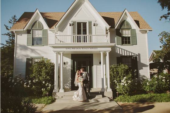 Couple's portrait in front of old victorian farm house