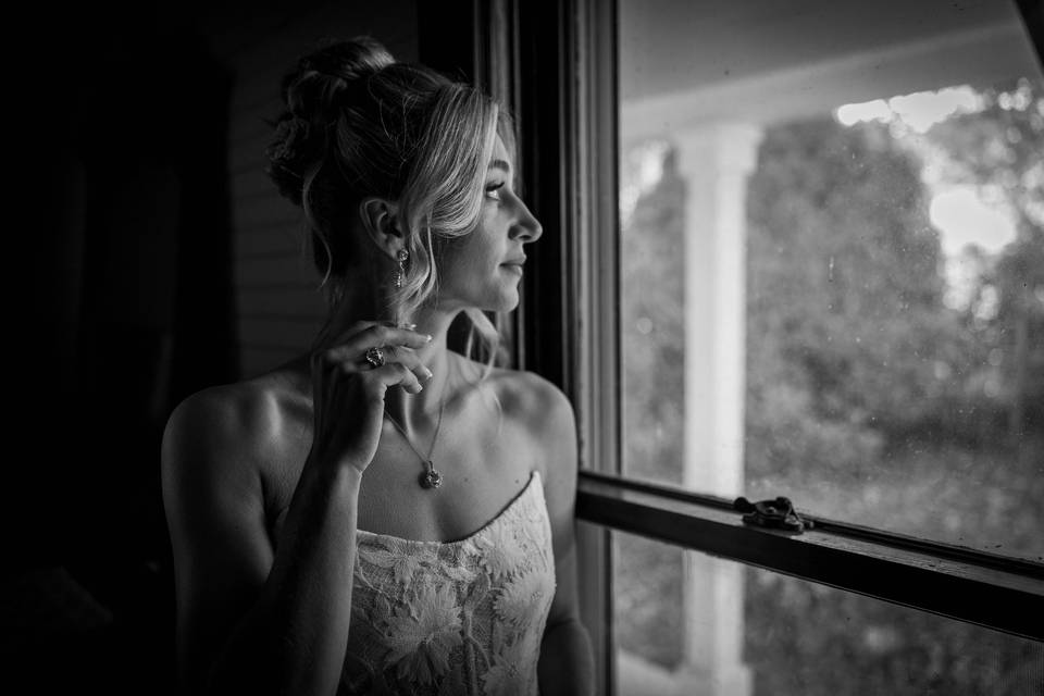 Bride Looking out Farmhouse