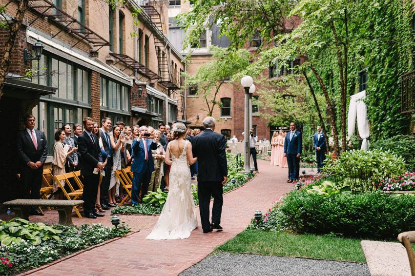 Bride & father walking down aisle for ceremony in courtyardPhoto Credit: T&S Hughes Photographyhttp://tandshughesphotography.com/