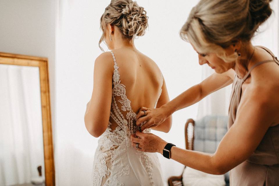 Mom lacing up the bride!
