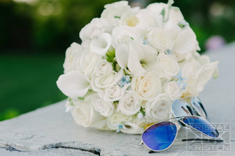 All white bridal bouquet with a touch of blue tweedia