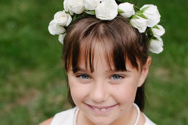 Sweet flower girl holding one of the bridesmaids bouquets for this blue nautical themed wedding
