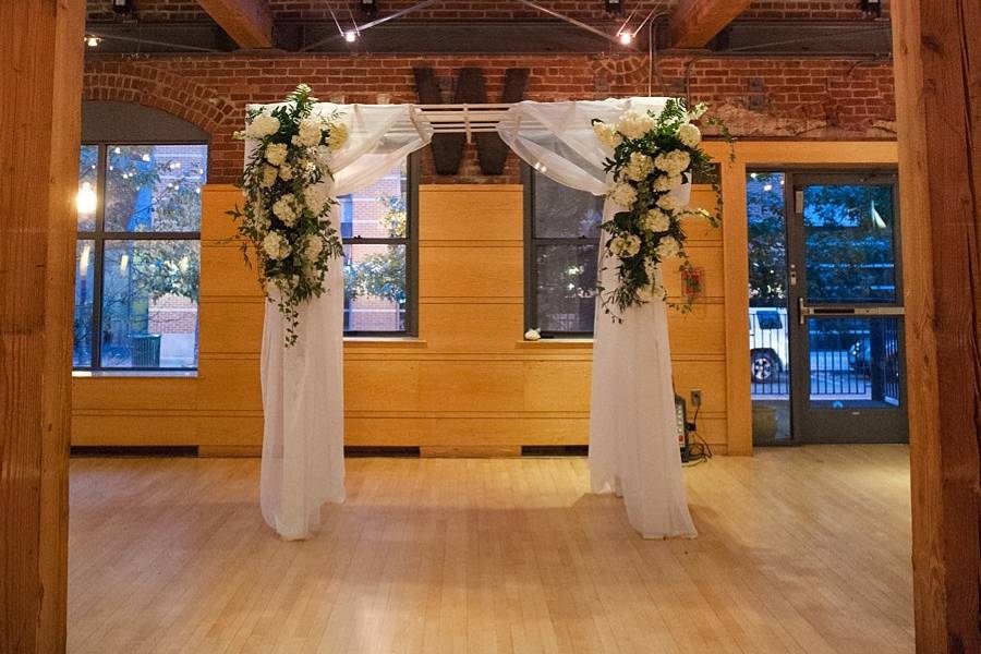 Romantic reception space: Chuppah with white fabric and white flowersPhoto by robertandkathleen.com