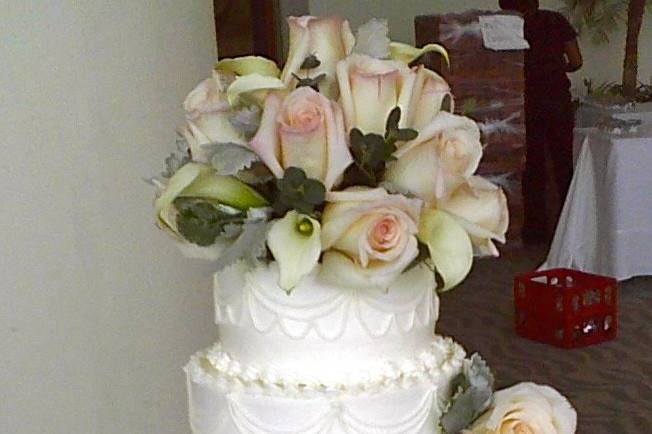 White textured cake with rose toppers