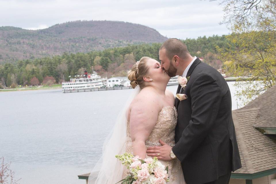 Newlyweds posing beside lake