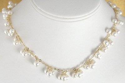 This beautiful bridal necklace is made with 6mm Swarovski pearls that have been wire wrapped onto 14-K gold filled chain. The pearls are wire wrapped onto the chain in three pearl clusters interspersed throughout.
The necklace measures 17 inches and has a 14-k gold filled lobster clasp.