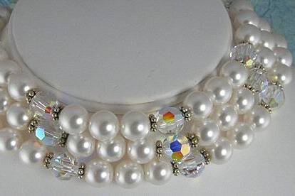 This stunning chocker is made with large 12mm Aurora Borealis clear Swarovski crystals, 12mm white Swarovski pearls and sterling silver daisy spacers.
The design of this choker is reminds me of the roaring twenties. The choker measures 15 inches in length and has a sterling silver three strand hook clasp with a two inch extender.