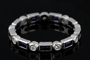 Art Deco Design Diamond and French Cut Sapphires Eternity Wedding Ring 18K Goldhttp://www.orospot.com/product/b78063mh/art-deco-design-diamond-and-french-cut-sapphires-eternity-wedding-ring-18k-gold.aspxSKU: B78063MH $1,699.00This timeless 18K white gold wedding band is 2.7mm wide and 1.8 mm tall. This Art Deco style band contains 9 French cut, channel set sapphires (.70Cttw) and 9 burnish set round brilliant diamonds (GVS quality .15cttw) . Sides are high polish and top milgraied. Band is available in all sizes. Please allow 2- 3 weeks to complete the order.