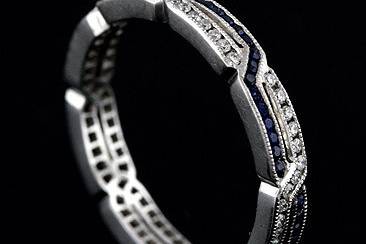 Art Deco Style 18K White Gold Diamond Sapphire Wedding Eternity Ringhttp://www.orospot.com/product/b54s01mh/art-deco-style-18k-white-gold-diamond-sapphire-wedding-eternity-ring.aspxSKU: B54S01MH $1,149.00This stylish ,art deco design, 18K white gold eternity band contains round diamonds (Brilliant cut Approx.23cttw, G-VS quality) channel set and round sapphires (Round cut Approx .23cttw). This Art Deco inspired eternity ring is 2.9mm wide and approx 1.65mm tall. It is hand set, edges are milgrained. Also available with rubies and diamonds (please contact us for more information). Band can be ordered in all sizes. Please allow 2- 3 weeks to complete this order.