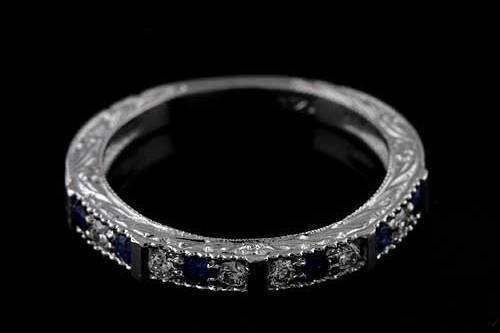 Prong Set Diamonds And Sapphire Engraved 14K White Gold Art Deco Reproduction Wedding Bandhttp://www.orospot.com/product/b2074wpp/prong-set-diamonds-and-sapphire-engraved-14k-white-gold-art-deco-reproduction-wedding-band.aspxSKU: B2074WPP$579.00Art Deco style inspired wedding band contains six prong set, natural, round diamonds .15cttw, G-SI1 quality and six round, blue sapphire approx .15cttw. Ring is 2.8 mm wide at the top of the shank and it is 2.2 wide at the bottom of the shank. The height at the top is 2.5 mm and the height at the bottom of the shank is 1.6 mm. Band is beautiful engraved 3/4 way and milgrained on the edges. Please allow 1-2 weeks to complete this order.
