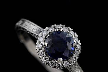 Diamond Round Blue Sapphire Engraved Vintage Style Engagement Ringhttp://www.orospot.com/product/r1070vens/diamond-round-blue-sapphire-engraved-vintage-style-engagement-ring.aspxSKU: R1070VENS$1,299.00This beautiful halo engagement ring is made of 14k white gold. Ring contains round diamond cut, blue sapphire center stone (approx. 1ct.), diamonds (.16cttw, G-SI1 quality) 