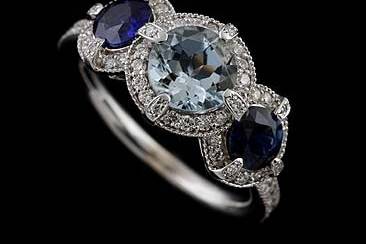 Diamond Aquamarine and Sapphire Engagement Ring 18K White Goldhttp://www.orospot.com/product/r1004ven/diamond-aquamarine-and-sapphire-engagement-ring-18k-white-gold.aspxSKU: R1004VEN$2,099.00This beautiful milgrained ring features aquamarine center stone (Approx. 1.19 cttw) and two side sapphires (Approx. 1.14cttw). Aquamarine and sapphires are surrounded by round brilliant cut diamonds in G-VS quality, that are set half way down the shank (.57cttw). All three center stones are set in prongs that have tiny accent diamonds on top of each one. The total width of this ring is approx. 10mm. The ring is made of solid 18K white gold and is high polished and rhodium plated. Available in all sizes, please contact us for your size preference.