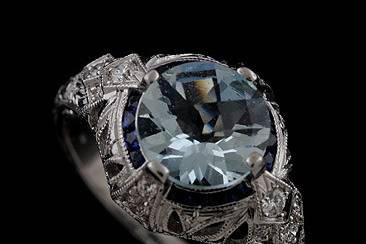 Diamond Sapphire Aquamarine Engraved Engagement Ring Mounting 18k White Goldhttp://www.orospot.com/product/r1052ven/diamond-sapphire-engraved-engagement-ring-mounting-18k-white-gold.aspxSKU: R1052VEN$1,699.00This beautiful, antique style engagement ring is made of 18k white gold. Center stone in NOT included but can be ordered separately from our diamond inventory. Ring can be created to fit any different, similar shape/size of center stone. Mounting contains 12 small, round cut diamonds .25ct, G-VS quality pave set and 16 princess cut, small sapphires. Whole ring is milgrained on the edges and high polished. To achieve the highest quality, this vintage style ring is custom hand engraved (not casted or computer generated). Unique engagement ring can be ordered in all finger sizes, please contact us for your size preference. Please allow 2-3 weeks to complete the order.