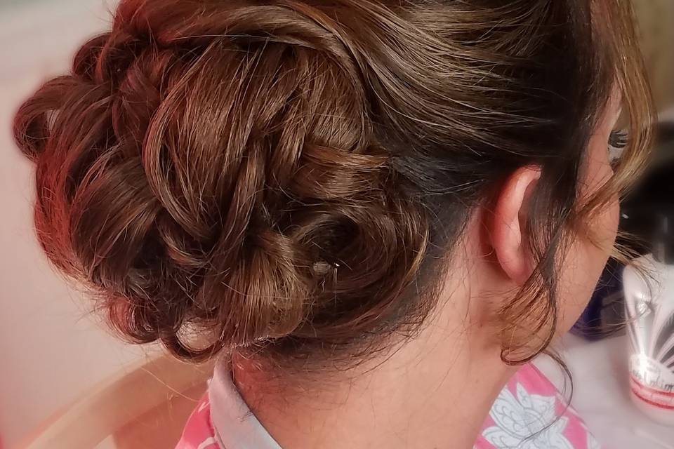 Curled hair tied into a low bun