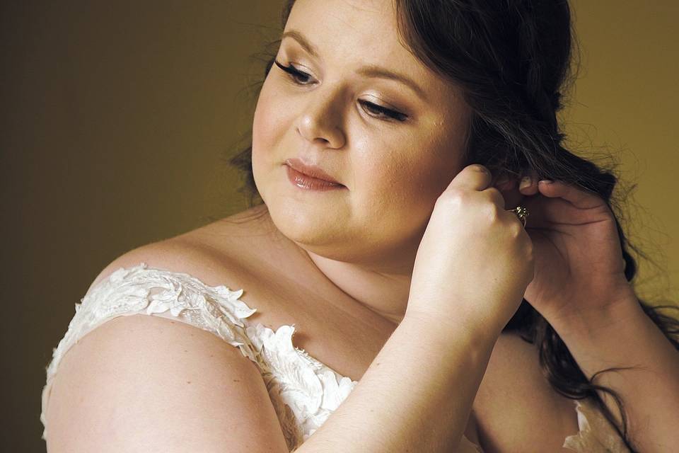 Bride putting on earrings