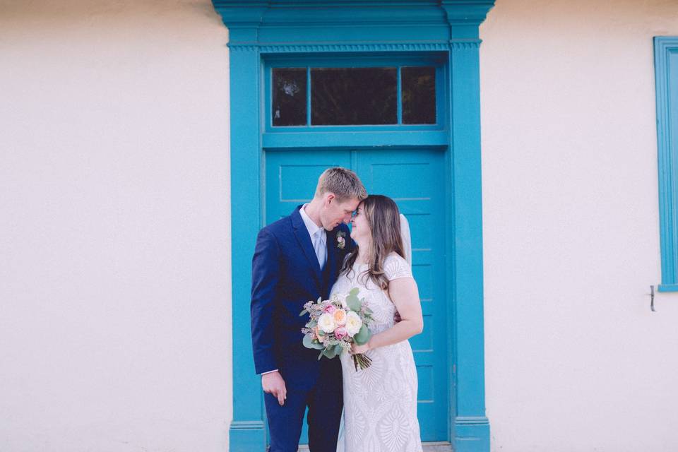 Couple pose in front of blue door