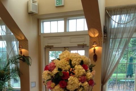 Lush ball arrangement on mercury pilsner vase designed with white hydrangea ,pink peonies,pink roses and a touch of lemon leaf