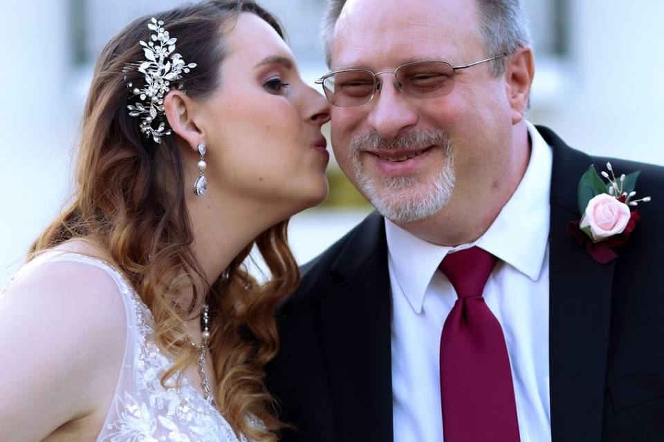 Bride giving a kiss to the dad