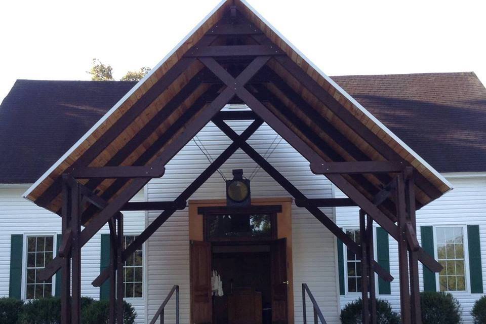 Our portico large porch area with ramp entrance to right side .  Chairs on Lawn