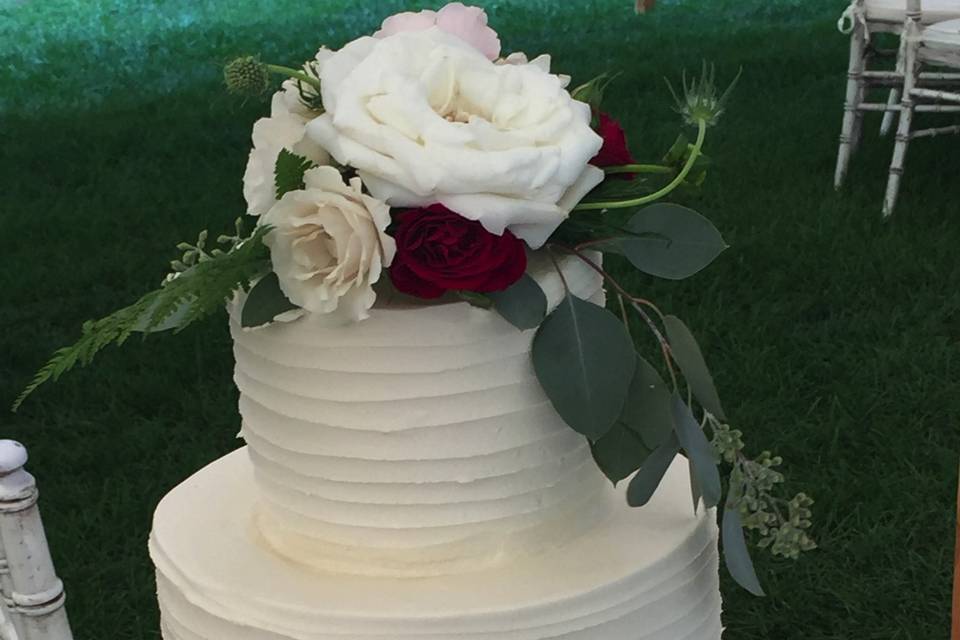 White wedding cake with white and red flowers