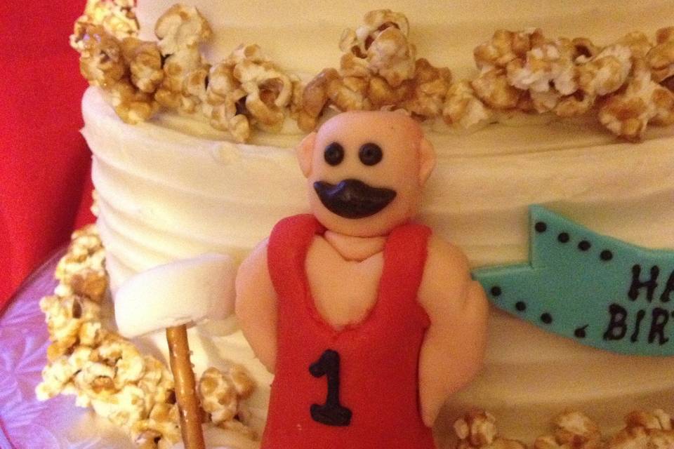 Close up of Strong Man and marshmallow/pretzel barbel on Leo's cake.