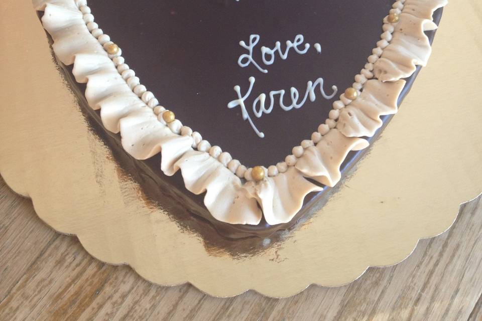 Dark chocolate heart-shaped brownie with espresso buttercream ruffle and pearl detail.