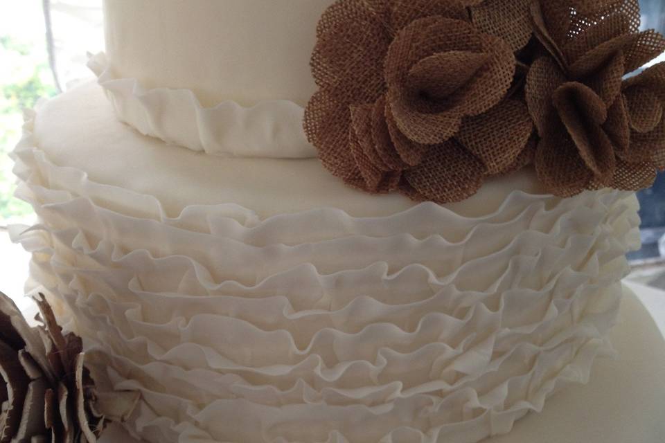 Close-up of burlap and lace wedding cake