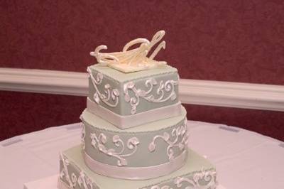 Cake has piping on the side with a chocolate monogram on top