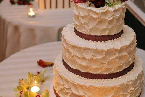 Cake is covered in sugar flowers with hand painted detail