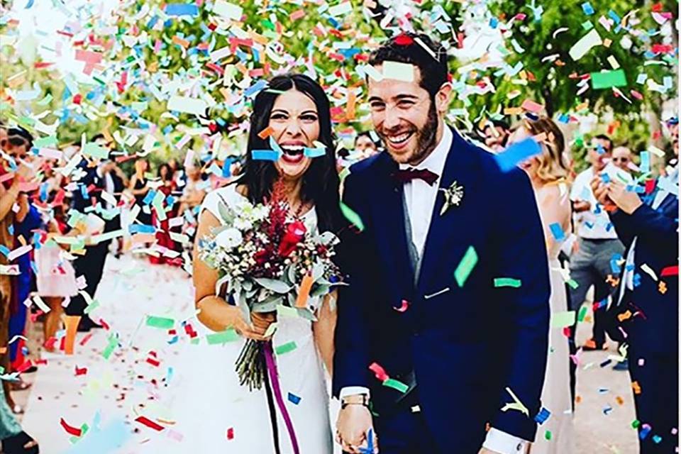 Multi-color confetti falling on the newlyweds