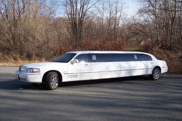 White 8 passenger Lincoln Town Car with 5th door