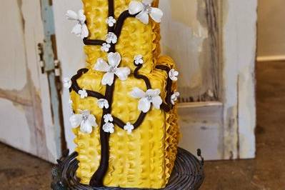 Mustard yellow ruffle cake with branch and dogwood flowers from enlightened patisserie